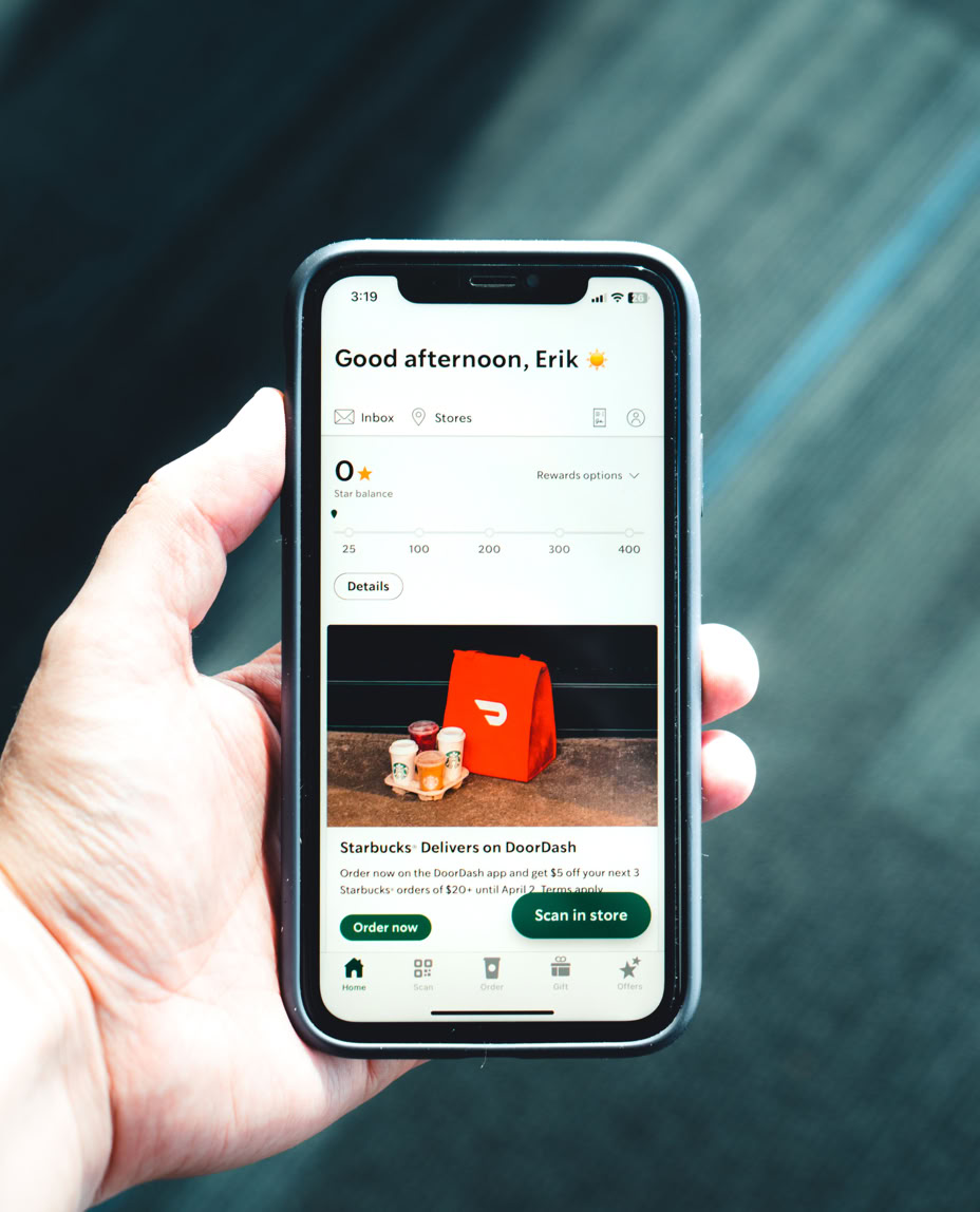 Photo of a Hand Holding a Phone with a Delivery App on Screen